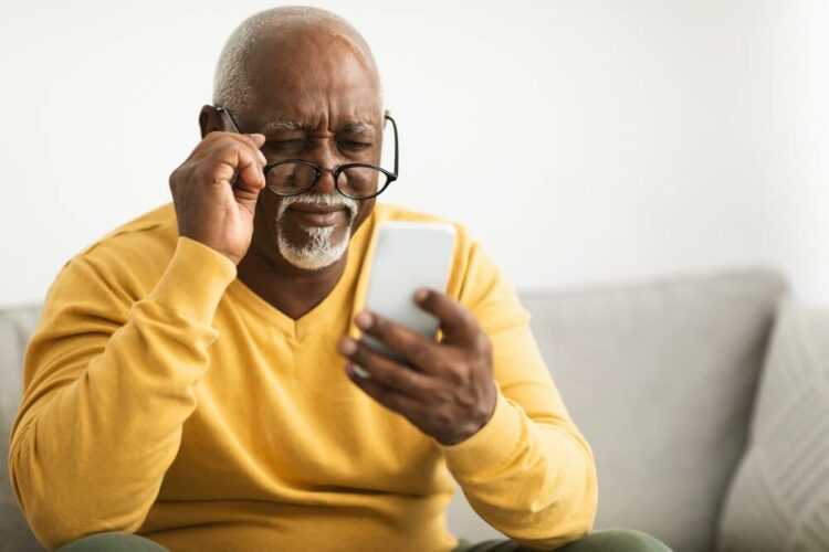 Older man straining to look at his phone